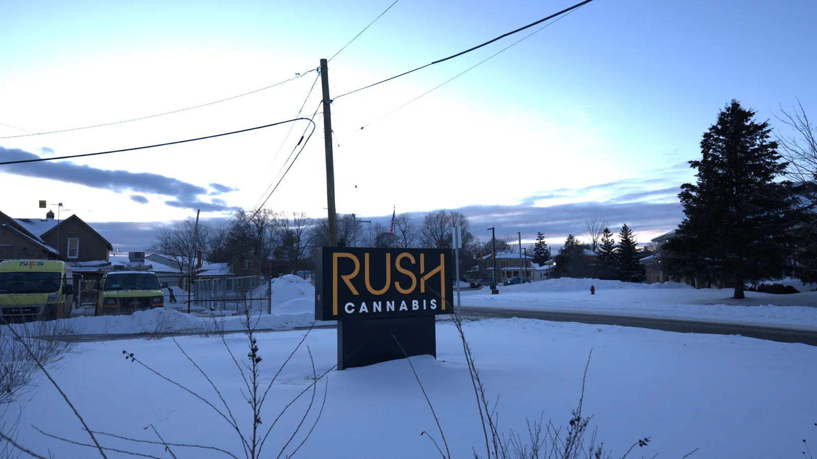 The RUSH Cannabis monument sign at the Oxford store, lit gold against a winter sky